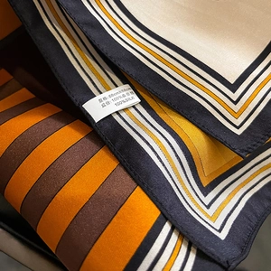 Close-up of 100% mulberry silk square scarf with vintage geometric patterns and labels