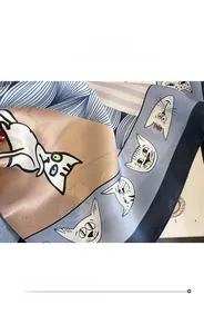 Gros plan détaillé des ourlets fins et du motif de chat sur le foulard en soie