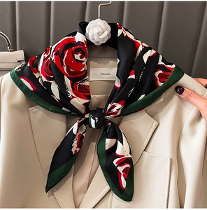 Gros plan d'un foulard en soie à motif rose rouge noué sur un col de costume