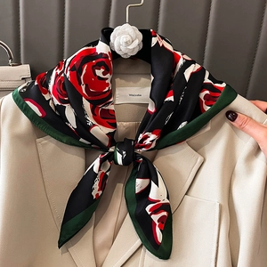 Foulard en soie élégant à motif roses rouges noué sur une veste de blazer blanche