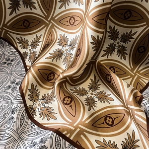 Close-up of silk scarf fabric showing retro geometric pattern and smooth texture