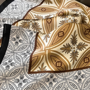 Close-up of silk square scarf featuring baroque patterns with gold and brown motifs