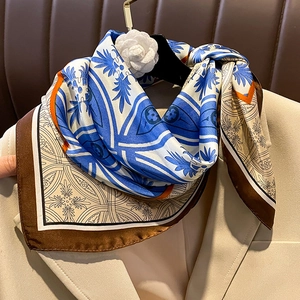 Elegant small silk square scarf with floral print and camellia brooch on beige suit