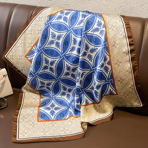 Detail of vintage geometric silk scarf with feather patterns on leather sofa