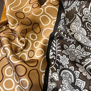 Close-up of silk-like scarf with paisley pattern and geometric ring prints