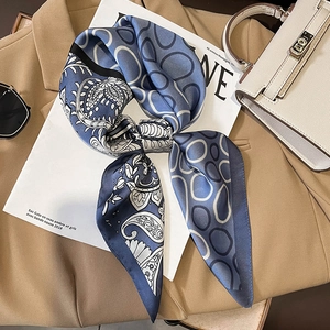 Blue and grey paisley satin silk square scarf styled with elegant suit and sunglasses