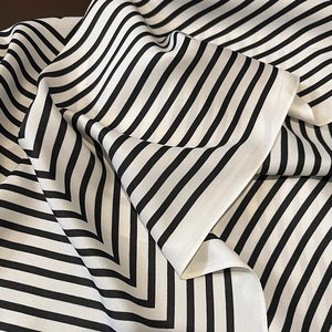 Detailed view of striped silk scarf texture showing soft fabric and geometric patterns