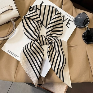 Detailed close-up of striped silk scarf with elegant satin finish on a tan blazer