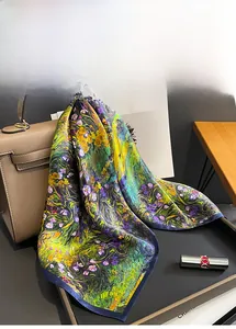 Détail d'un foulard en soie imprimé peinture à l'huile drapé sur un sac en cuir de luxe