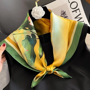 Elegant silk scarf with lotus print in yellow and green tied on a black dress