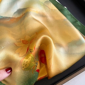 Elegant golden silk scarf with lotus print and refined green hand-rolled edges