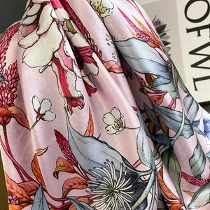 Glossy silk scarf with pink floral print shown in detailed drape and smooth texture