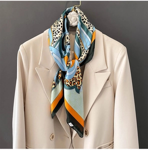 Detail of silk scarf with leopard print and geometric patterns on a blazer