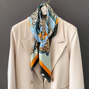 Elegant silk-feel leopard print square scarf with geometric pattern on cream blazer