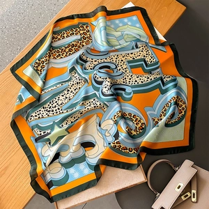 Detailed pattern of leopard print and geometric motifs on satin silk scarf
