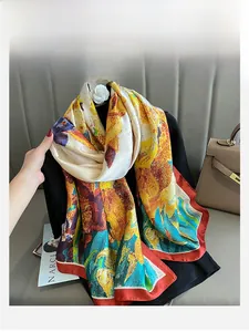 Detailed close-up of artistic floral oil painting silk scarf with red stitched edges