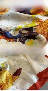 Close-up of fine machine-stitched edges and artistic oil painting print on silk scarf