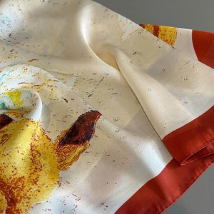 Close-up of silk scarf showing artistic giraffe pattern and smooth lustrous texture