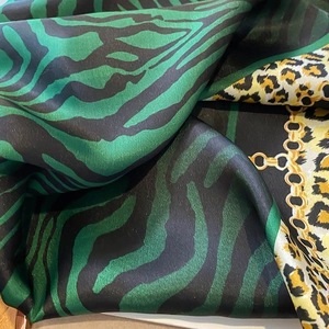 Close-up of leopard and zebra print silk scarf with luxury golden chain patterns