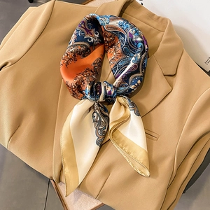 Silk square scarf with paisley pattern styled on a blazer for a chic autumn look