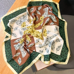 Detailed view of the silk scarf folding on a desk showing smooth texture and drape
