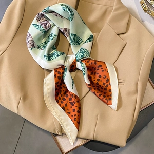Elegant satin silk scarf with green leaf and leopard print on a camel blazer