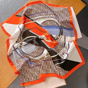 Detailed close-up of silk scarf showing equestrian patterns and houndstooth texture