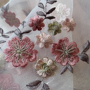 Close-up of 3D floral embroidery on silk blend scarf with pink petals and gold thread