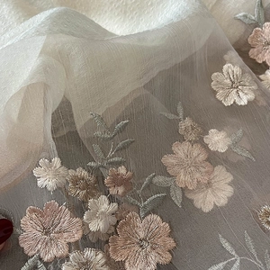Close-up of elegant floral embroidery on a translucent silk blend warm scarf shawl