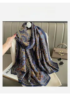 Vue détaillée d'un foulard en soie à motif Paisley avec finition satinée et tons dorés