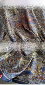 Vue macro détaillée du foulard en soie paisley avec couture précise sur tissu bleu marine