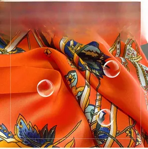 Detail of nautical print silk scarf featuring anchor and rope patterns in orange and blue