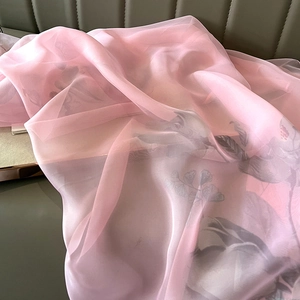 Macro shot of semi-transparent pink floral silk scarf with elegant grey leaf patterns
