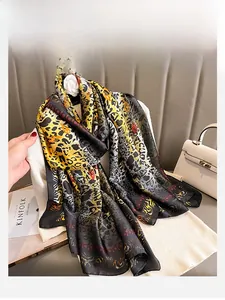 Détail de l'imprimé animalier sur foulard en soie avec pull blanc et accessoires