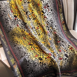 Détail d'un foulard en soie à imprimé léopard avec des accents paisley rouges sur cuir
