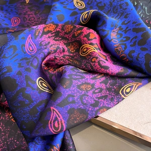 Gros plan d'une écharpe en soie avec imprimé léopard et motifs paisley élégants