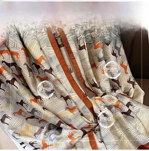 Gros plan du foulard en soie montrant des motifs de chevaux et texture satinée