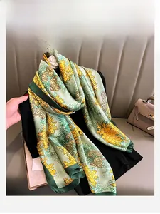 Close-up of silk scarf with green floral chrysanthemum and cloud patterns