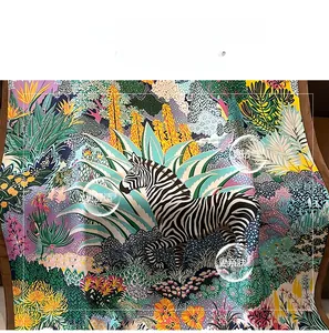 Detail of printed silk scarf featuring tropical jungle pattern with zebras and cacti