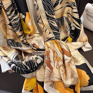 Longue écharpe en soie aux motifs floraux et géométriques en jaune, noir et beige