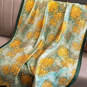 Detail of silk scarf with golden chrysanthemum pattern and retro cloud texture