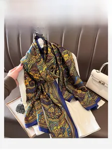 Detailansicht eines Paisley-Seidenschals gestylt über einem weißen Strickpullover