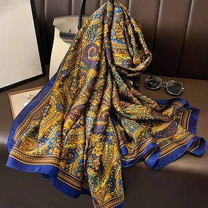 Eleganter Seidenschal mit Paisley-Muster, drapiert über einer Tasche im Luxus-Stil