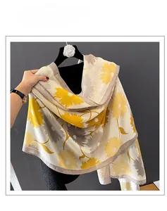 Détail d'un châle en coton et lin avec motif tournesol jaune et gris sur fond beige clair