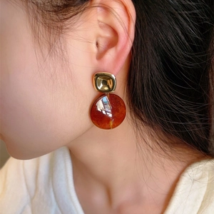 Boucles d'oreilles rétro en résine ambre et carrés dorés sur un modèle féminin