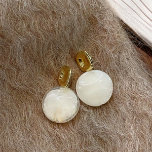 Boucles d'oreilles rétro en résine ambre avec carrés dorés sur tissu brun pelucheux