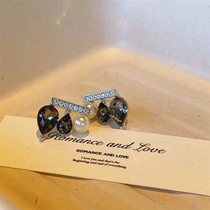 Unique seesaw stud earrings featuring black teardrop crystals and white pearls on silver