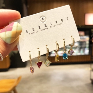 Detail of 6-piece gold hoop earring set with multi-colored heart and teardrop zircons