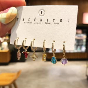Close-up of a 6-piece earring set featuring colorful crystal charms on gold hoops