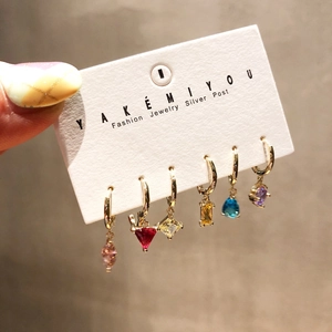 Detail of 6-piece colorful zircon earring set featuring gold hoops and silver posts